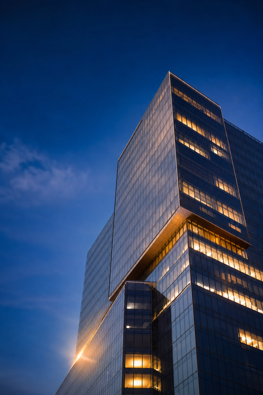 Modern glass office tower at dusk — 4J Insurance Agency, commercial insurance brokerage in Frisco, TX